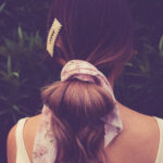 Rear view of a woman with a pink hair scrunchie and clip in her hair.